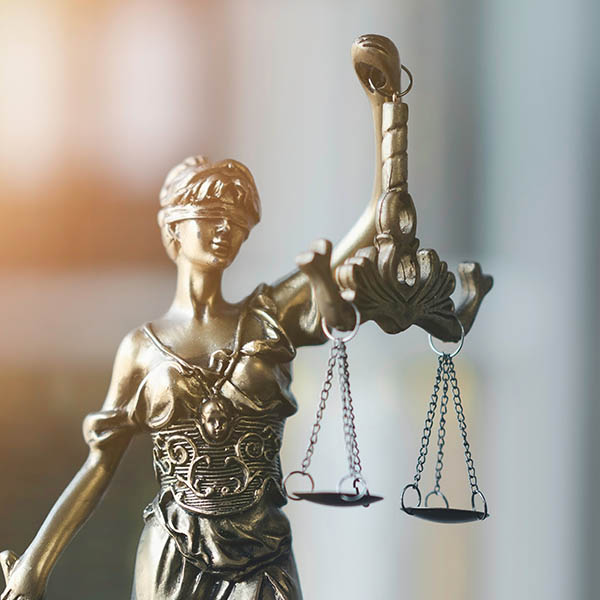 Lady justice statue holding scales and sword, symbolizing law, justice, and legal proceedings